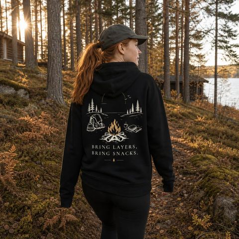 Bring Layers, Bring Snacks Hoodie, worn on a trail in the northern forest