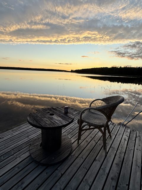 A wicker chair and cable drum table on the dock in the evening light
